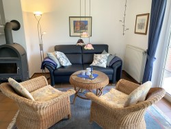 Foto: Ferienhaus Mien lüttje Huuske, Greetsiel: Nach einem aktiven Urlaubstag können Sie hier in der gemütlichen Sofalandschaft entspannen. Wenn Sie mögen, sogar am Kamin
